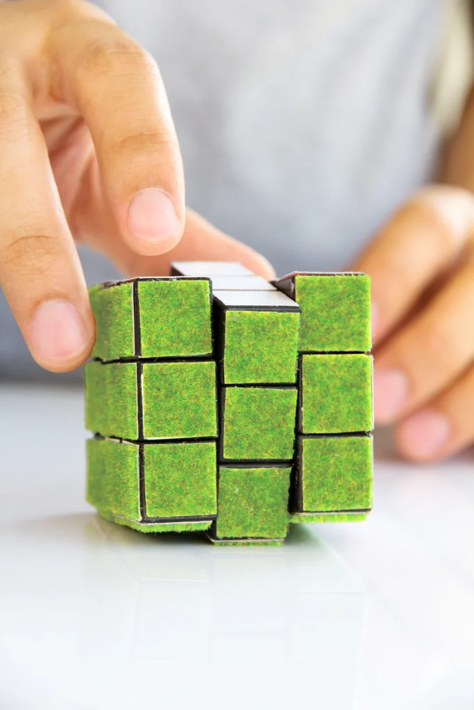 Eine Hand bewegt einen Zauberwürfel als Symbol für Prozessoptimierung und innovative Unternehmensstrategien.